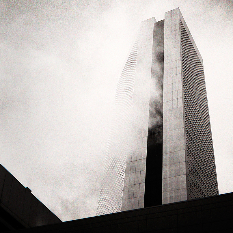 black and white sky scraper shrowded in steam